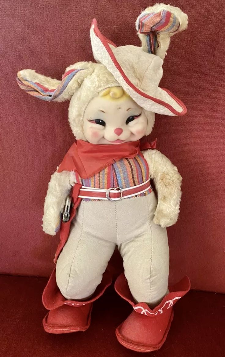 a white stuffed animal wearing red boots and a hat