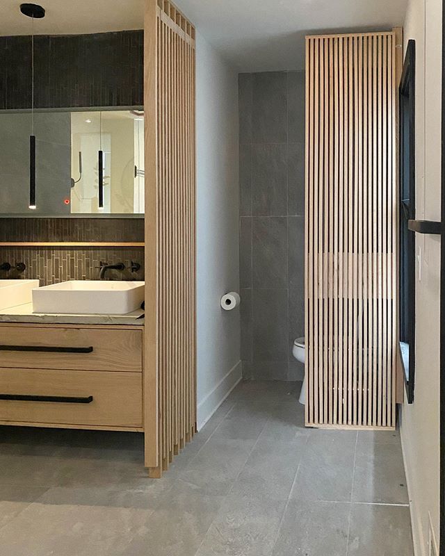 a bathroom with a sink, toilet and wooden partition