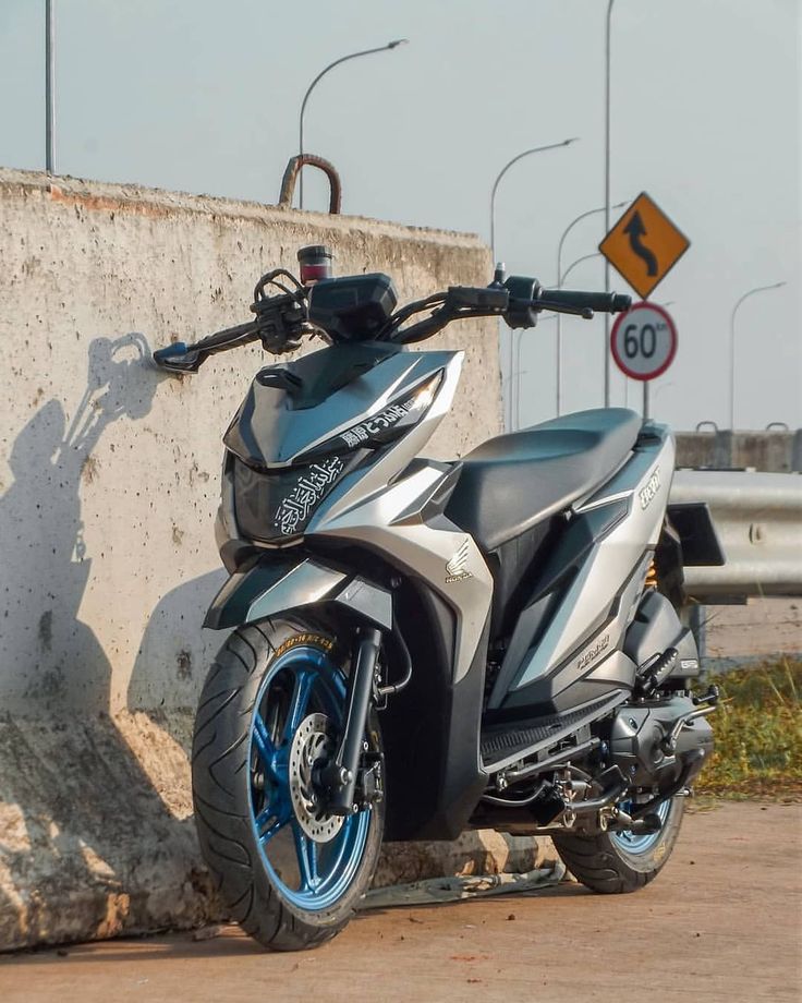 a motorcycle parked next to a concrete wall