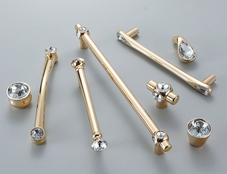 several different types of gold jewelry on a gray surface with diamond eyeshades and nose rings