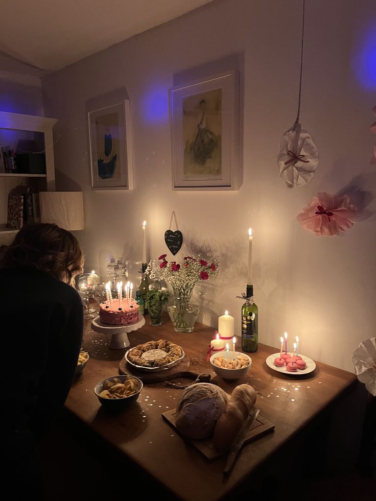 a woman sitting at a table with food and candles