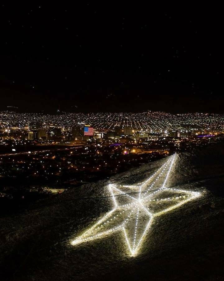 an airplane is flying in the sky over a city at night with lights on it