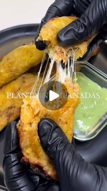 a person in black gloves is eating some food on a plate with green sauce and toothpicks