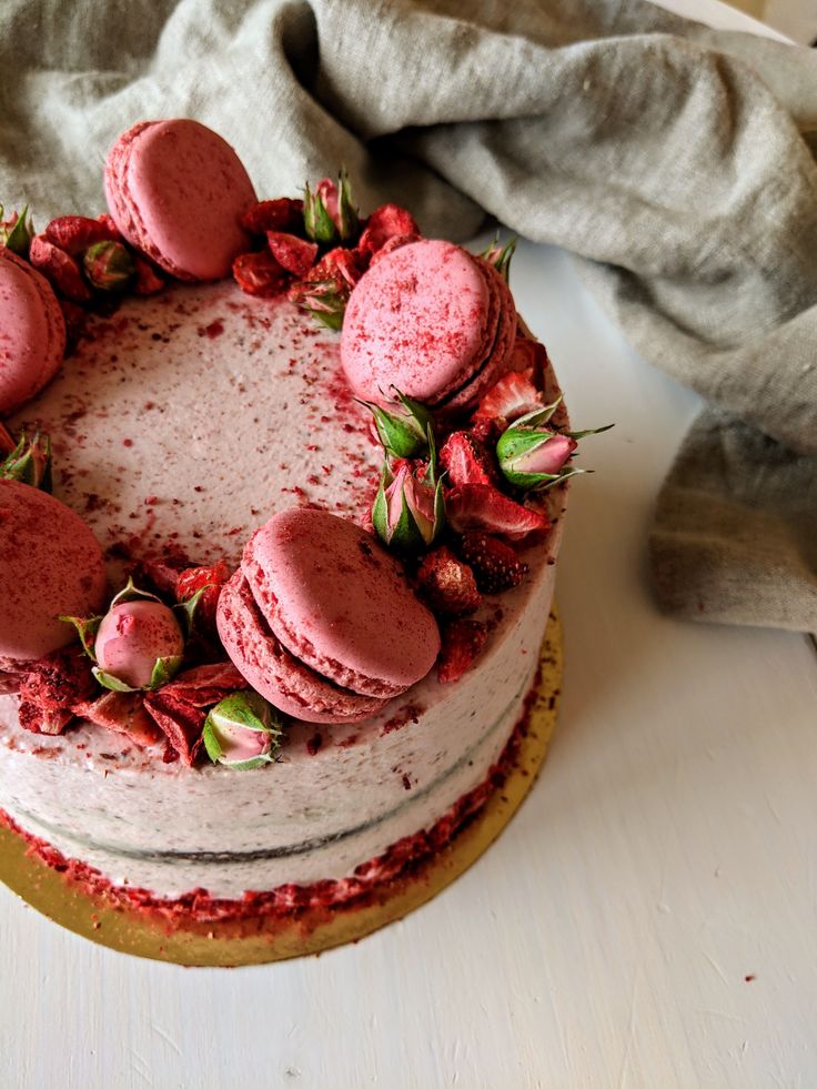 a cake with frosting and strawberries is on a table next to a napkin