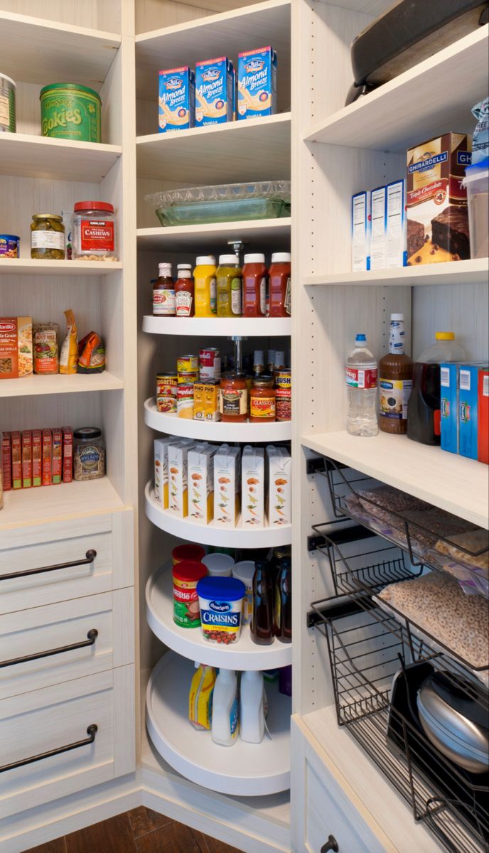 an organized pantry with white shelving and lots of food on the shelves, along with other items