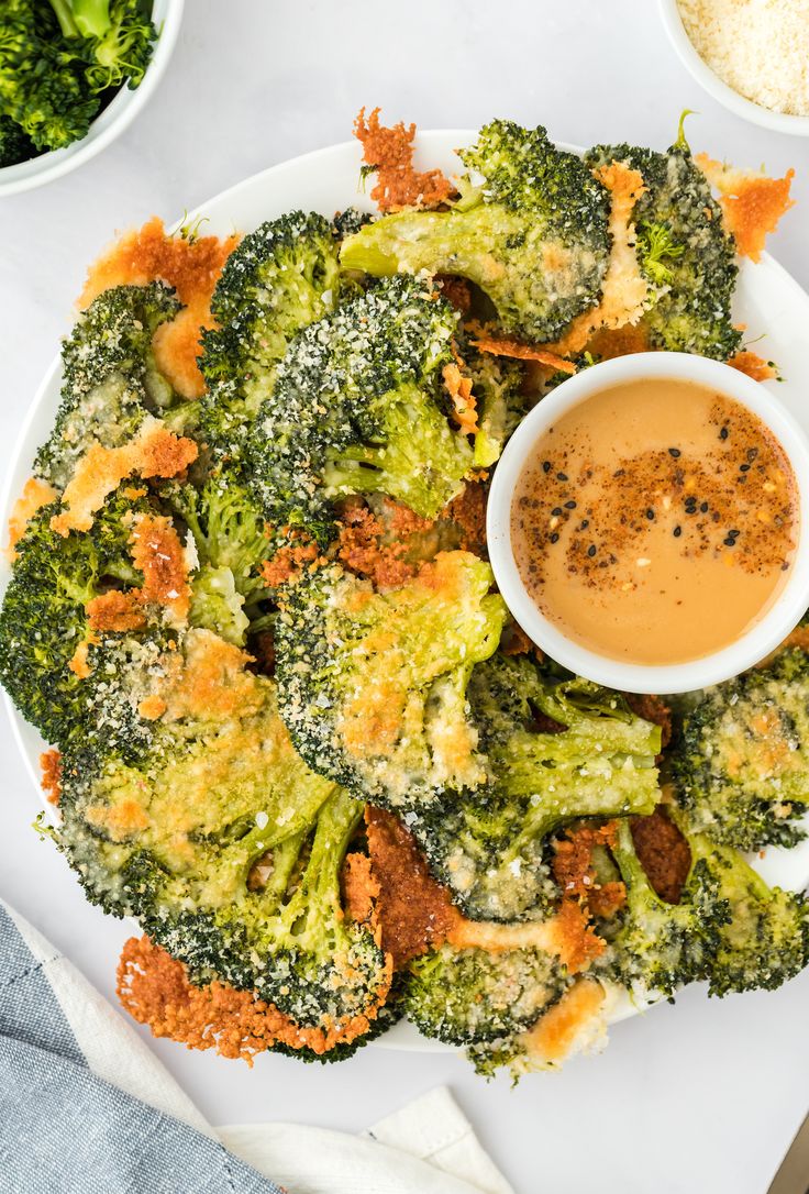 broccoli florets on a plate with dipping sauce