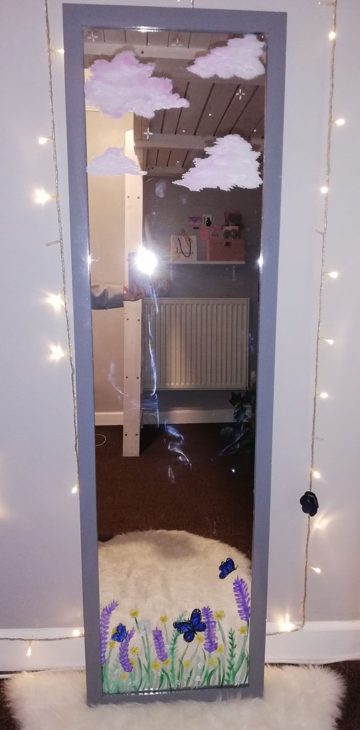 the door is decorated with purple flowers and white fluffy clouds, while lights are strung across the room