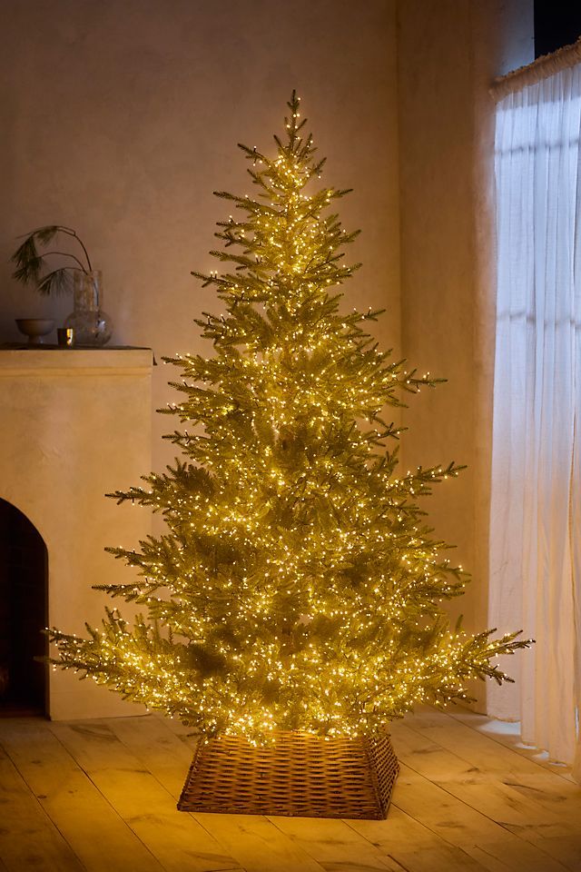 a lit christmas tree in a wicker basket