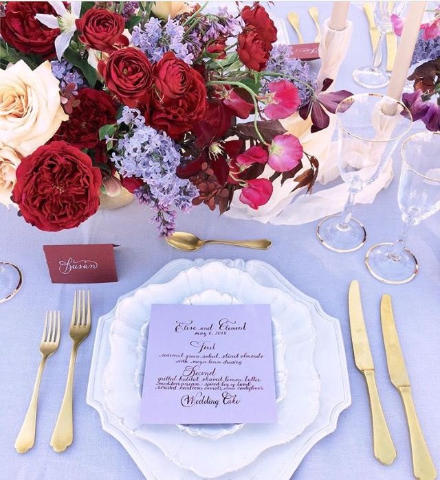 the table is set with flowers and silverware