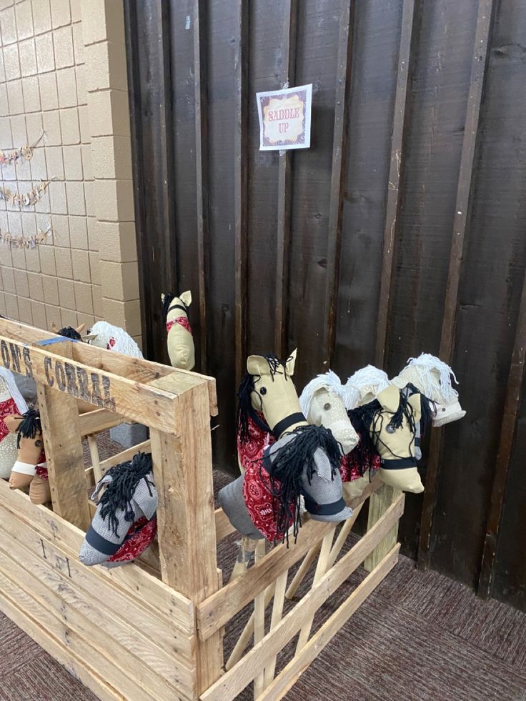 several stuffed animals are sitting in a wooden crate on the floor next to a wall