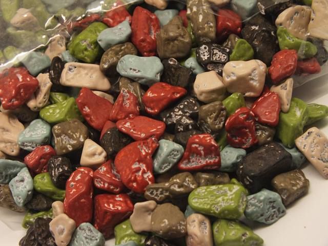 a pile of colorful rocks sitting on top of a white plate