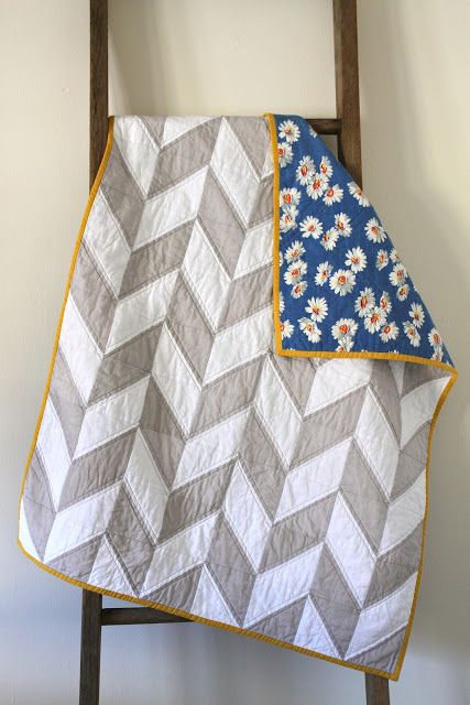 a quilted blanket sitting on top of a wooden ladder