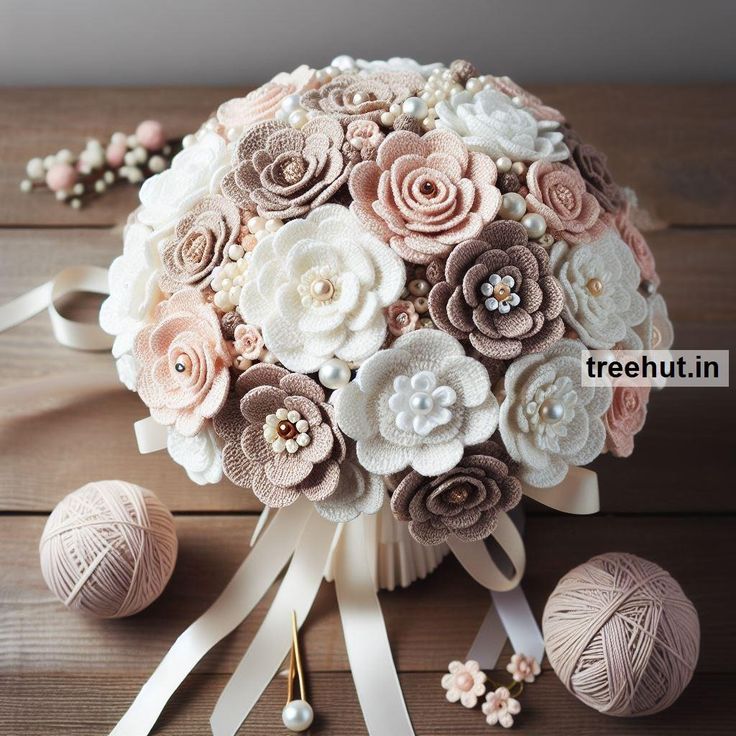 a bridal bouquet with white and pink flowers on it next to balls of yarn