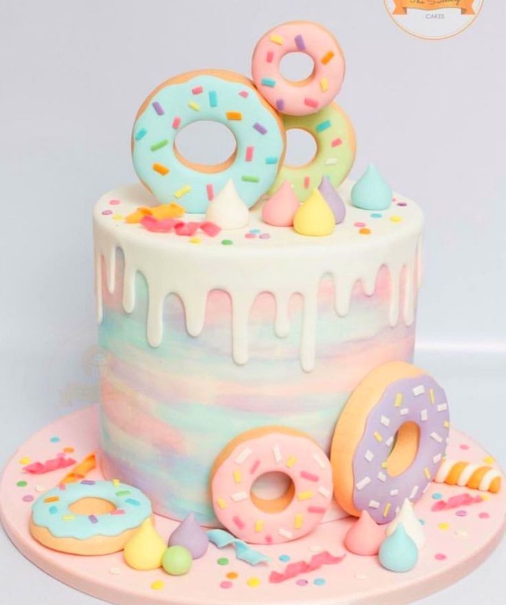 a birthday cake decorated with donuts and sprinkles