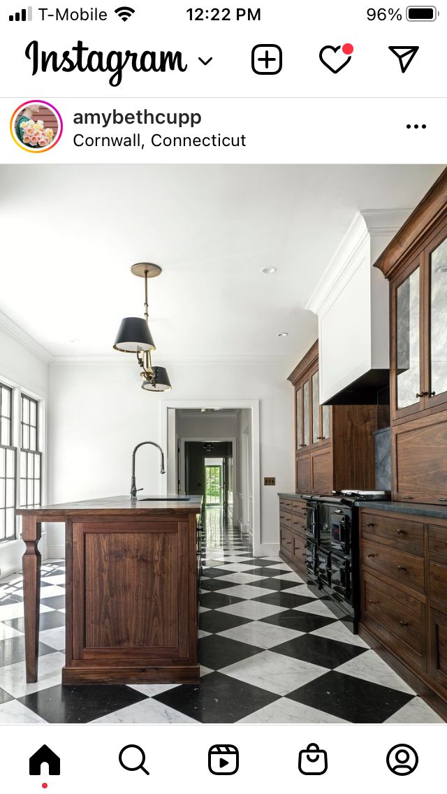 an instagram photo of a kitchen with black and white checkerboard flooring