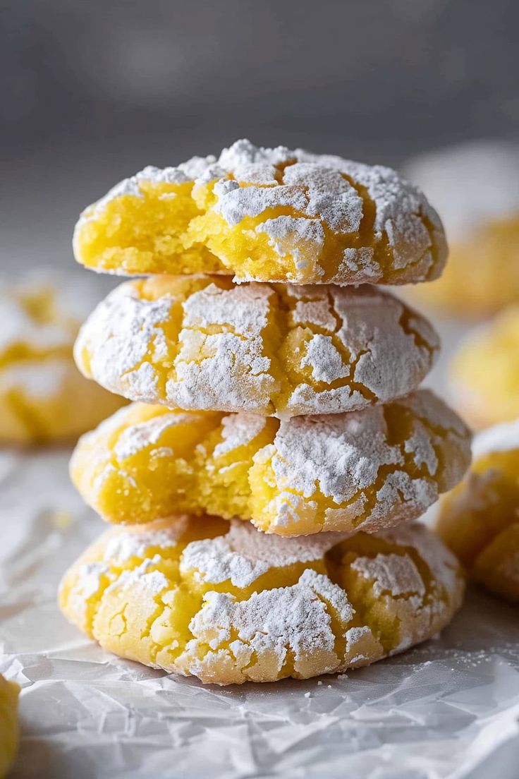 a stack of powdered sugar cookies sitting on top of each other next to lemons