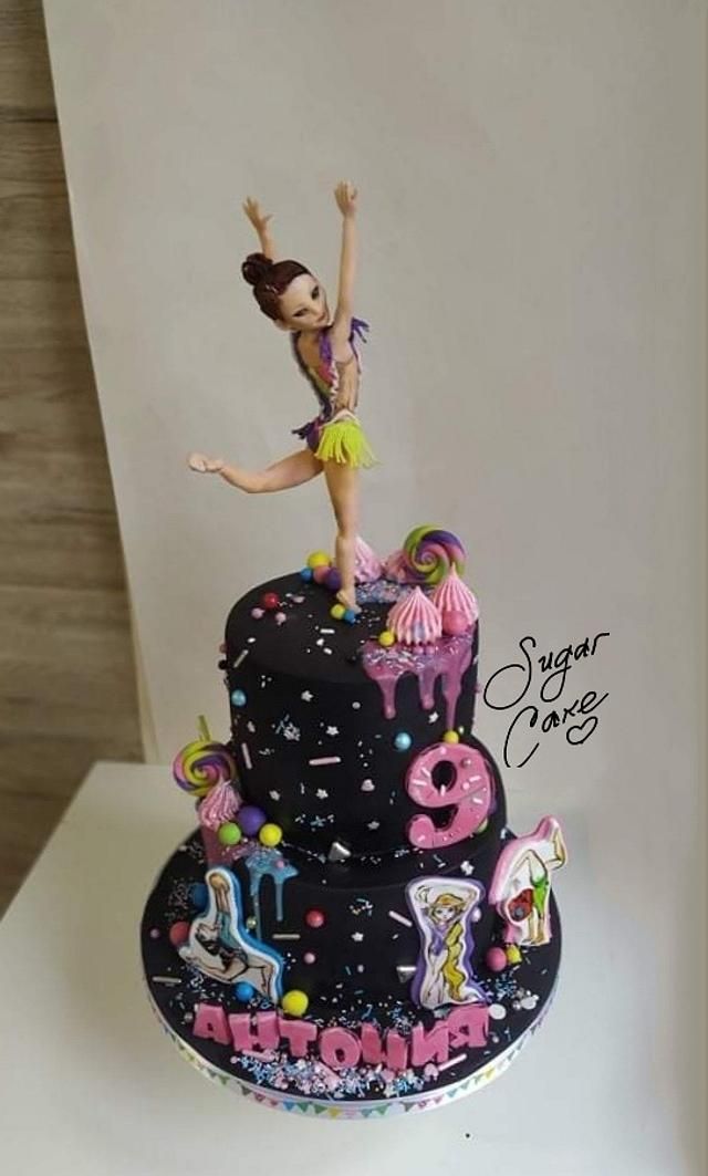 a birthday cake decorated with an image of a woman dancing on top of the cake