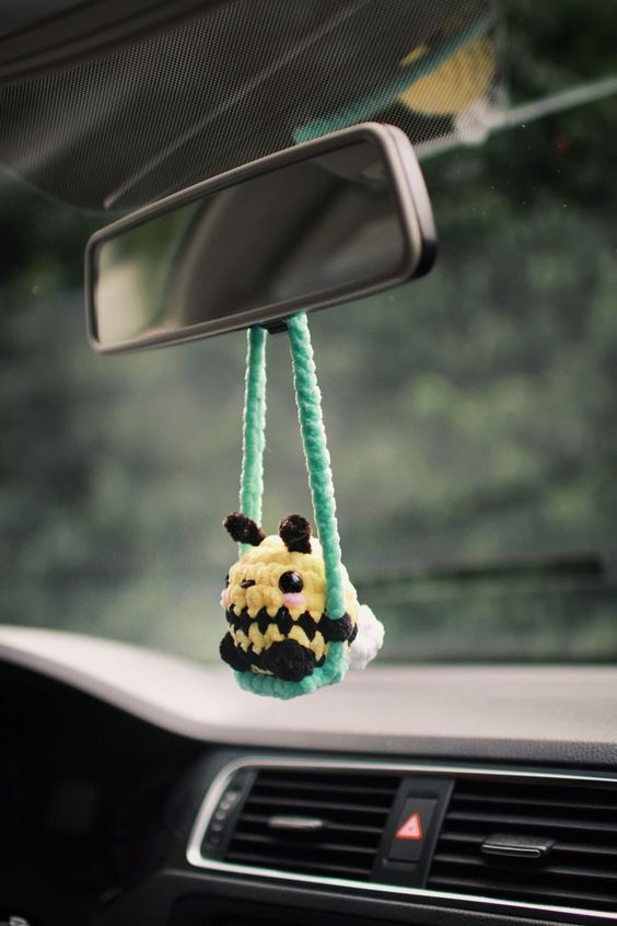 a stuffed animal hanging from the dashboard of a car