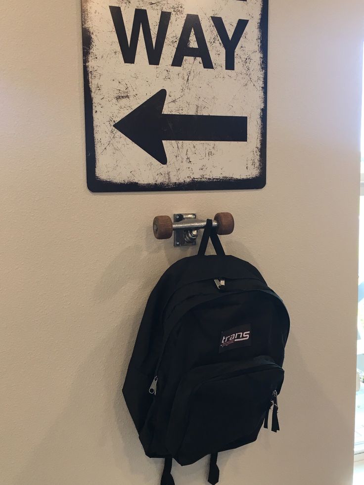 a backpack hanging on the wall next to a sign