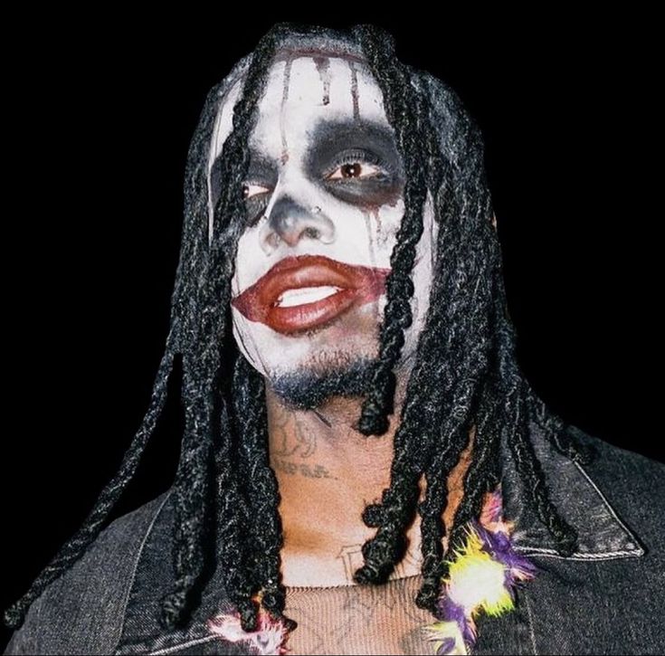 a man with dreadlocks and makeup on his face