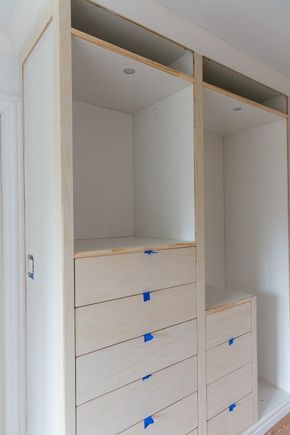 an empty closet with white drawers and blue tape