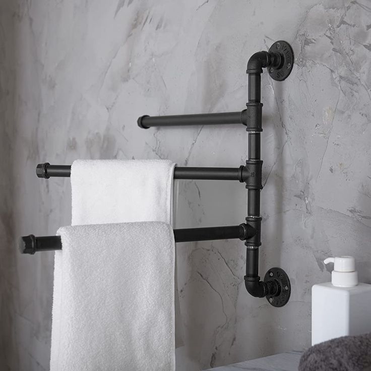 a bathroom with marble walls and black pipes