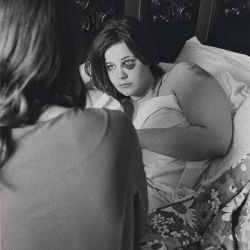 a woman laying in bed next to another woman