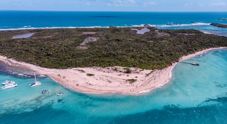 an island in the ocean with boats on it