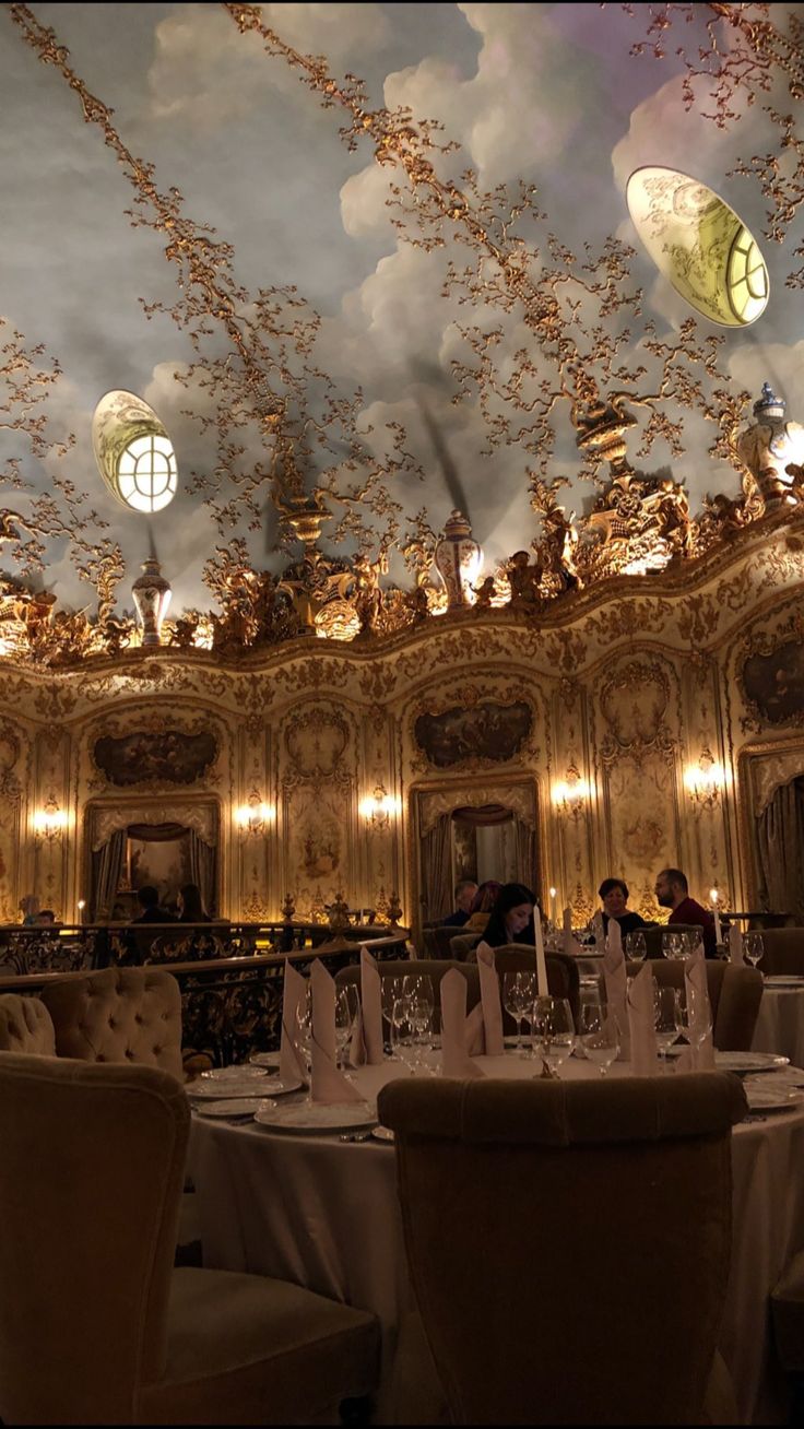 an ornately decorated dining room with chandeliers and white tablecloths on the tables