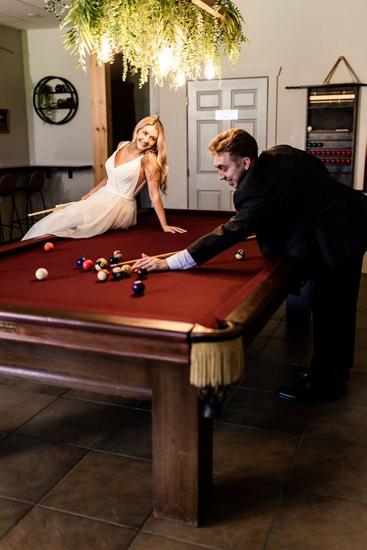 a man and woman playing pool in a room