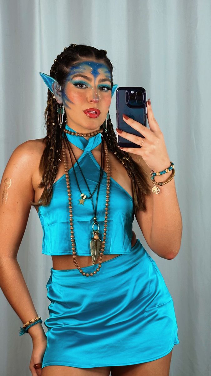 a woman with blue makeup is taking a selfie