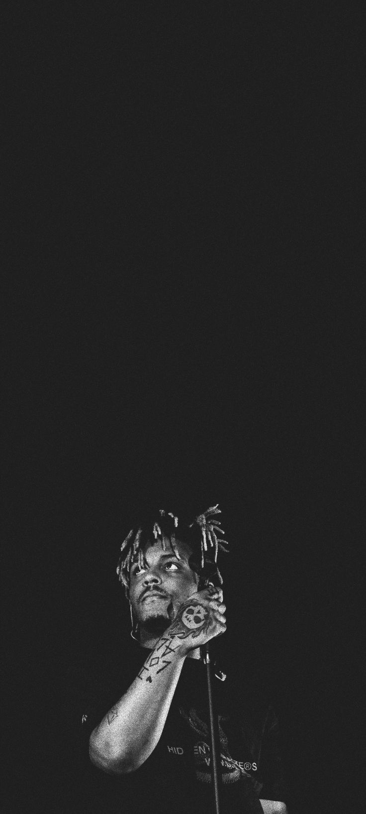 a black and white photo of a man holding a microphone in front of his face