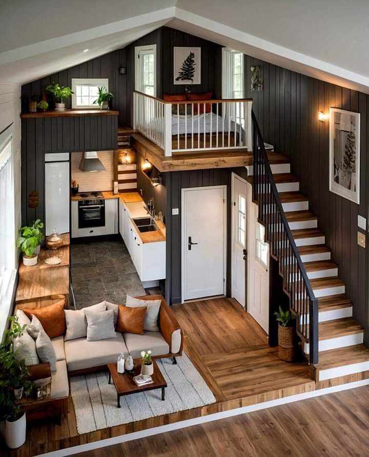 an overhead view of a living room and kitchen with stairs leading up to the second floor