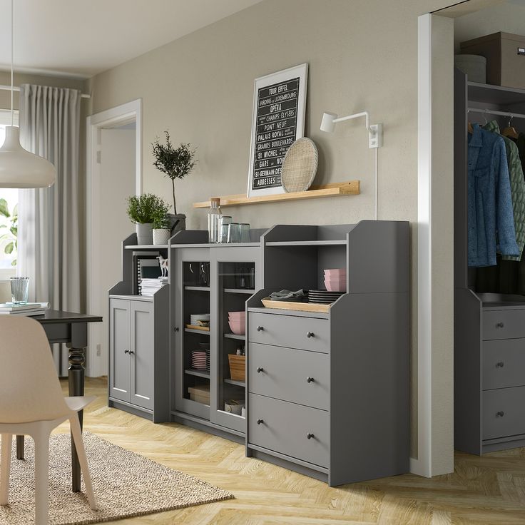 a room with a chair, desk and cabinets in the corner that are both grey