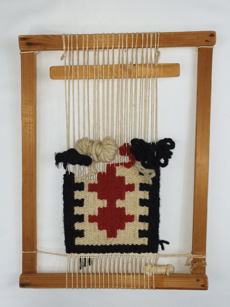 an old weaving project is hanging on a wooden frame