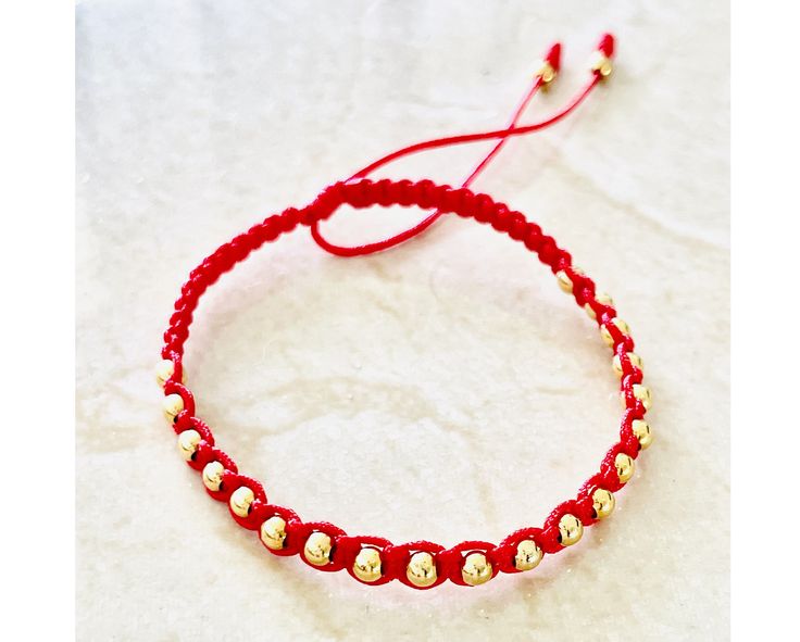 "Stylish gold-filled beaded red bracelet to add to your your go-to favorite bracelets Bracelet will arrive in a beautiful package with a sweet, meaningful blessing for you and loved ones that reads, \"𝙈𝙖𝙮 𝙮𝙤𝙪 𝙗𝙚 𝙋𝙧𝙤𝙩𝙚𝙘𝙩𝙚𝙙, 𝙃𝙖𝙥𝙥𝙮, 𝙃𝙚𝙖𝙡𝙩𝙝𝙮 𝙖𝙣𝙙 𝙒𝙚𝙖𝙡𝙩𝙝𝙮\". * Safe to get wet, gold-filled beads. * Waterproof Strings in beautiful vibrant red. * For women with best fit for wrist size 5 to 7.5inch. * Made in USA ♡ 𝗦𝗲𝗻𝗱 𝗮 𝗚𝗶𝗳𝘁 𝗠𝗲𝘀𝘀𝗮𝗴𝗲 You can write a Gold Macrame Braided Bracelets For Friendship, Gold Macrame Bracelets For Friendship, Gold Macrame Beaded Bracelet For Friendship, Gold Macrame Beaded Bracelets, Gold Hand Wrapped Friendship Bracelets, Gold Macrame Bracelets With Round Beads, Red Friendship Bracelets With Gold Beads As Gift, Gold Bracelets With Macrame Round Beads, Gold Braided Bracelets With Tiny Beads For Friendship