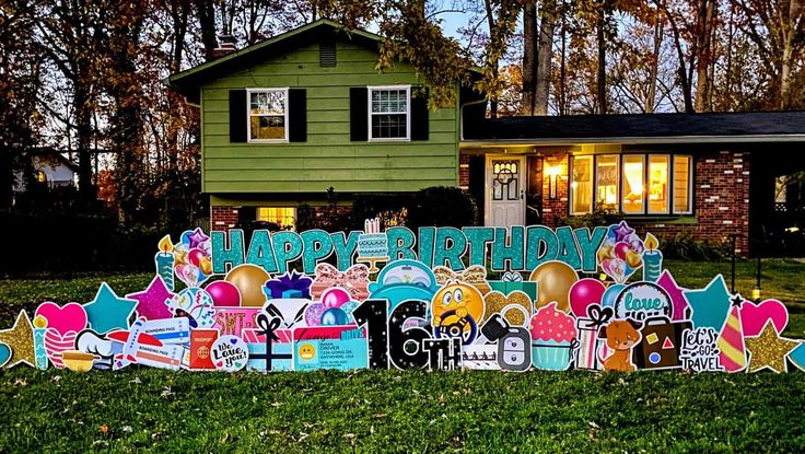 a large yard sign in front of a green house with lots of decorations on it