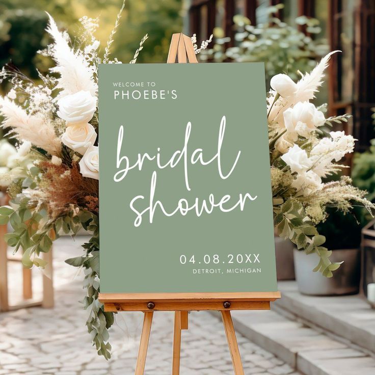 a sign that says bridal shower sitting on top of a easel with flowers