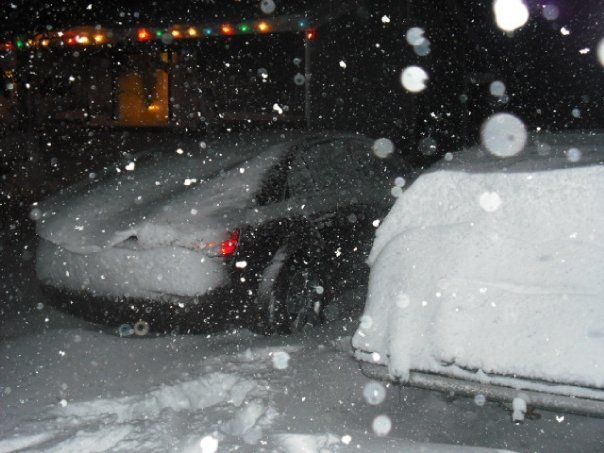 cars parked in the snow at night time