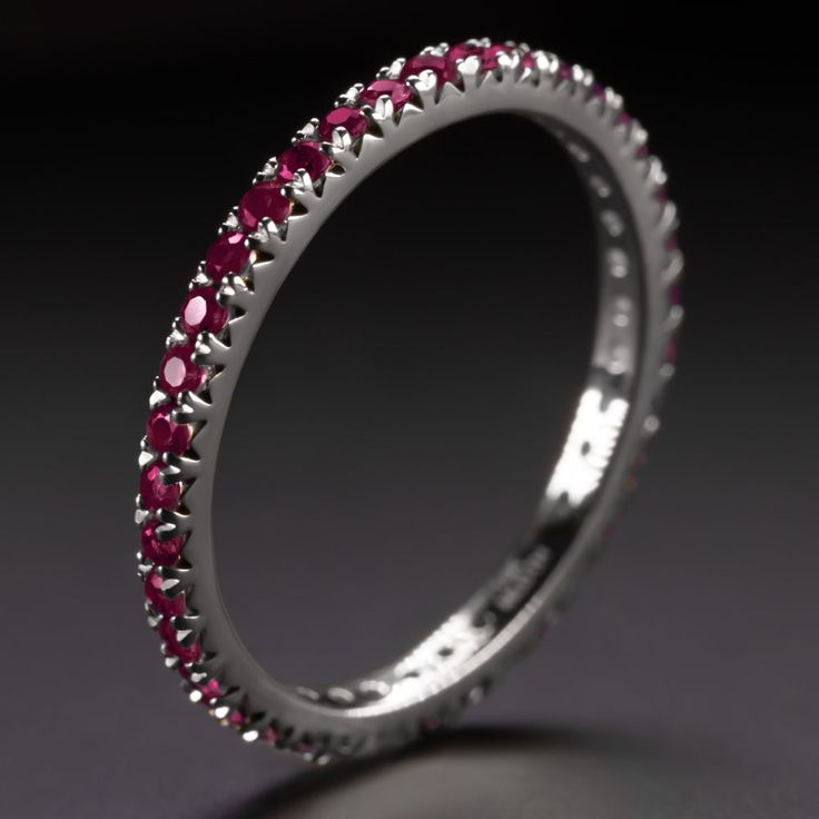 a white gold ring with red stones on it