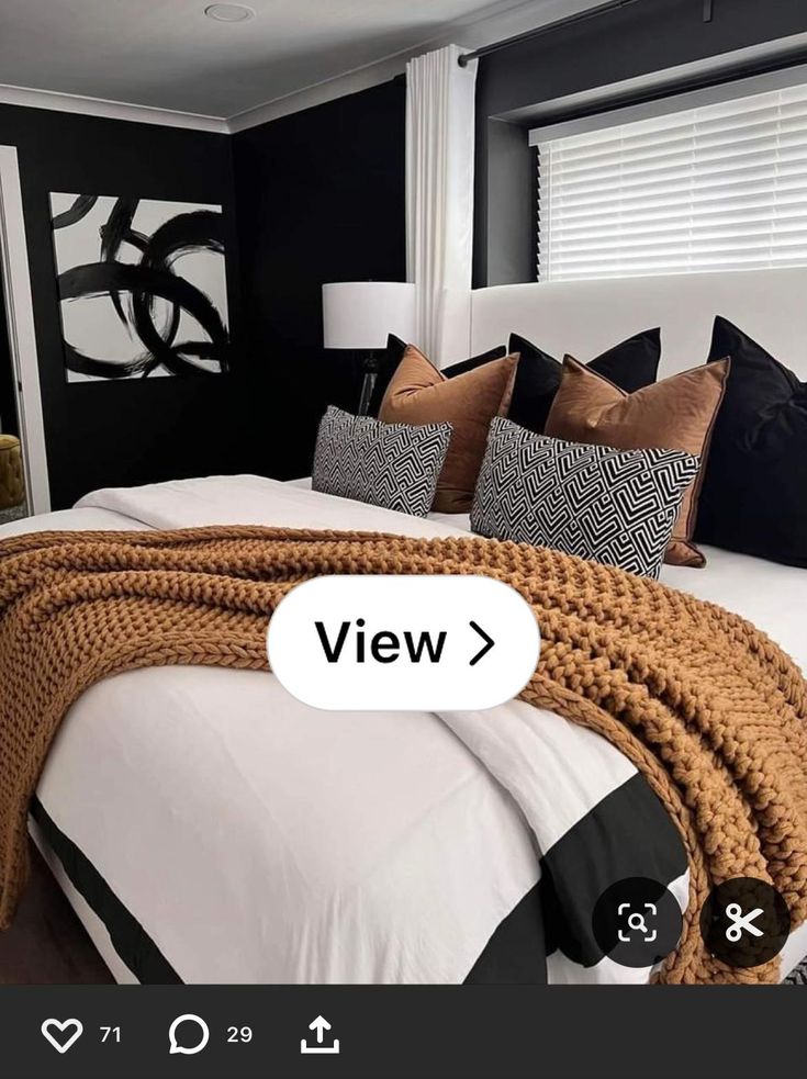 a bed that has some pillows on it and a blanket over the top of it