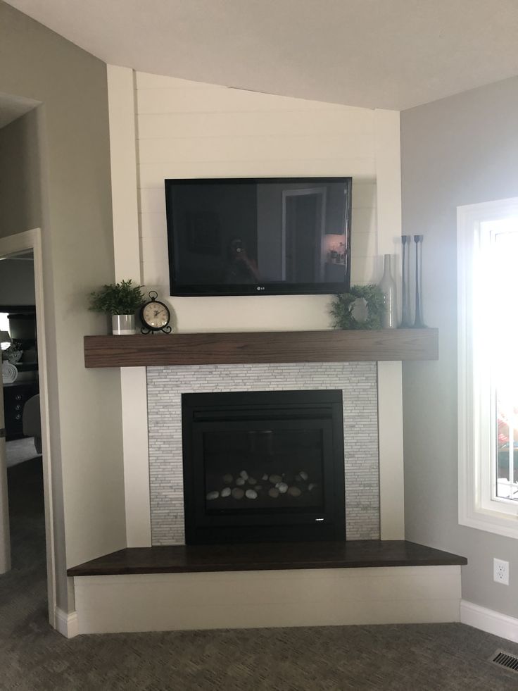 a fireplace with a flat screen tv mounted above it's mantle in a living room