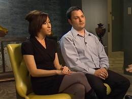 two people sitting in chairs talking to each other on the set of an interview with one person holding a microphone