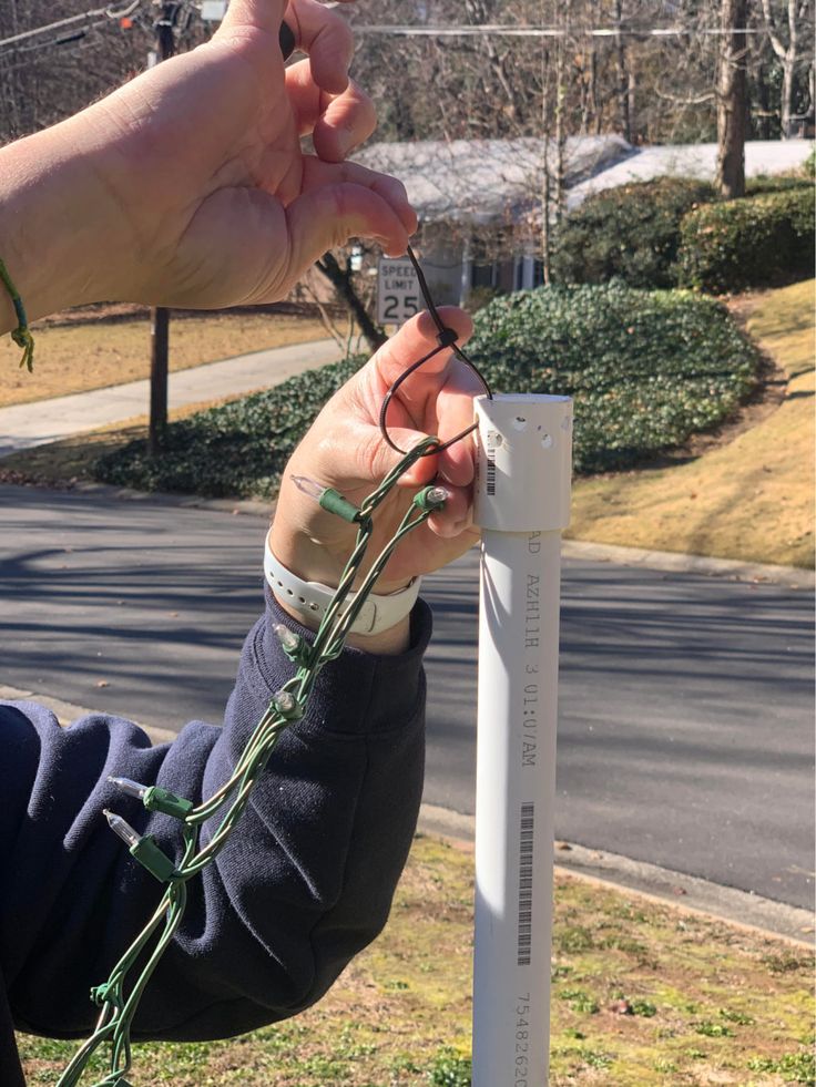 a person is trying to fix an electrical wire on a pole outside in the grass