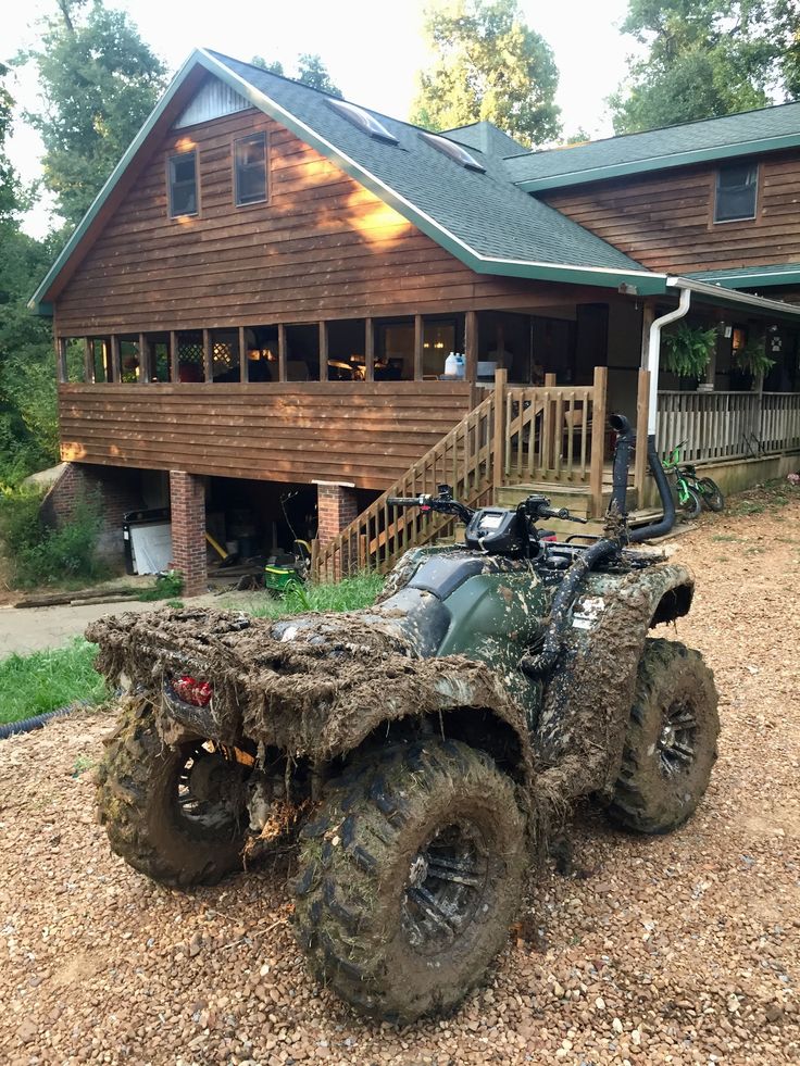 an atv is covered with mud in front of a house