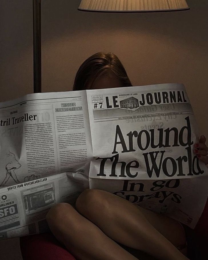 a woman sitting in a chair reading a newspaper