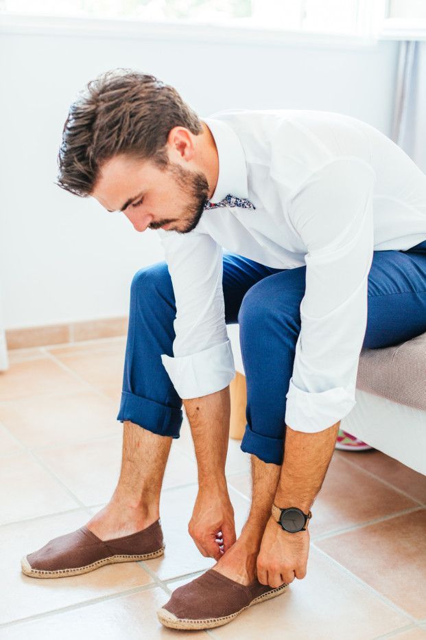 a man is tying his shoes on the floor