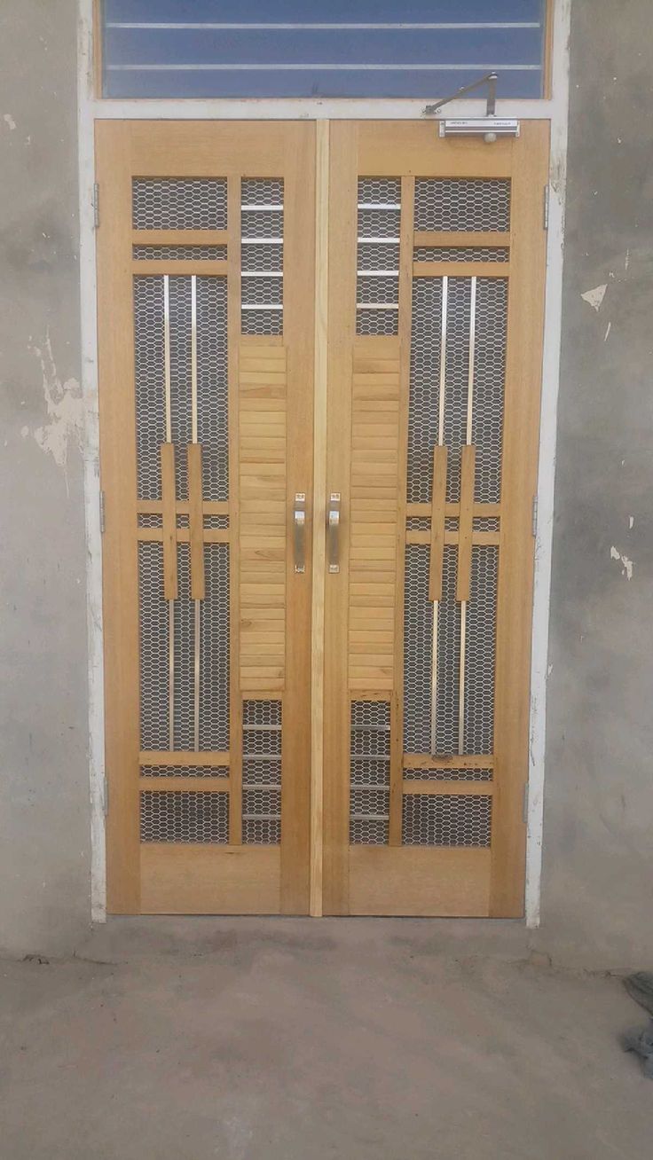 two wooden doors in front of a building