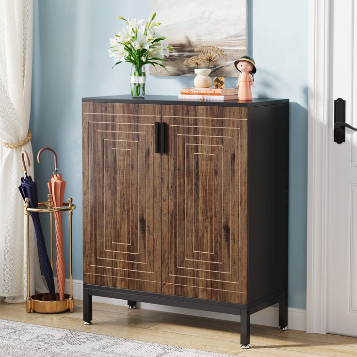 a wooden cabinet sitting on top of a hard wood floor next to a white door