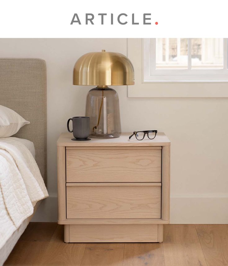 a nightstand with glasses on it next to a bed